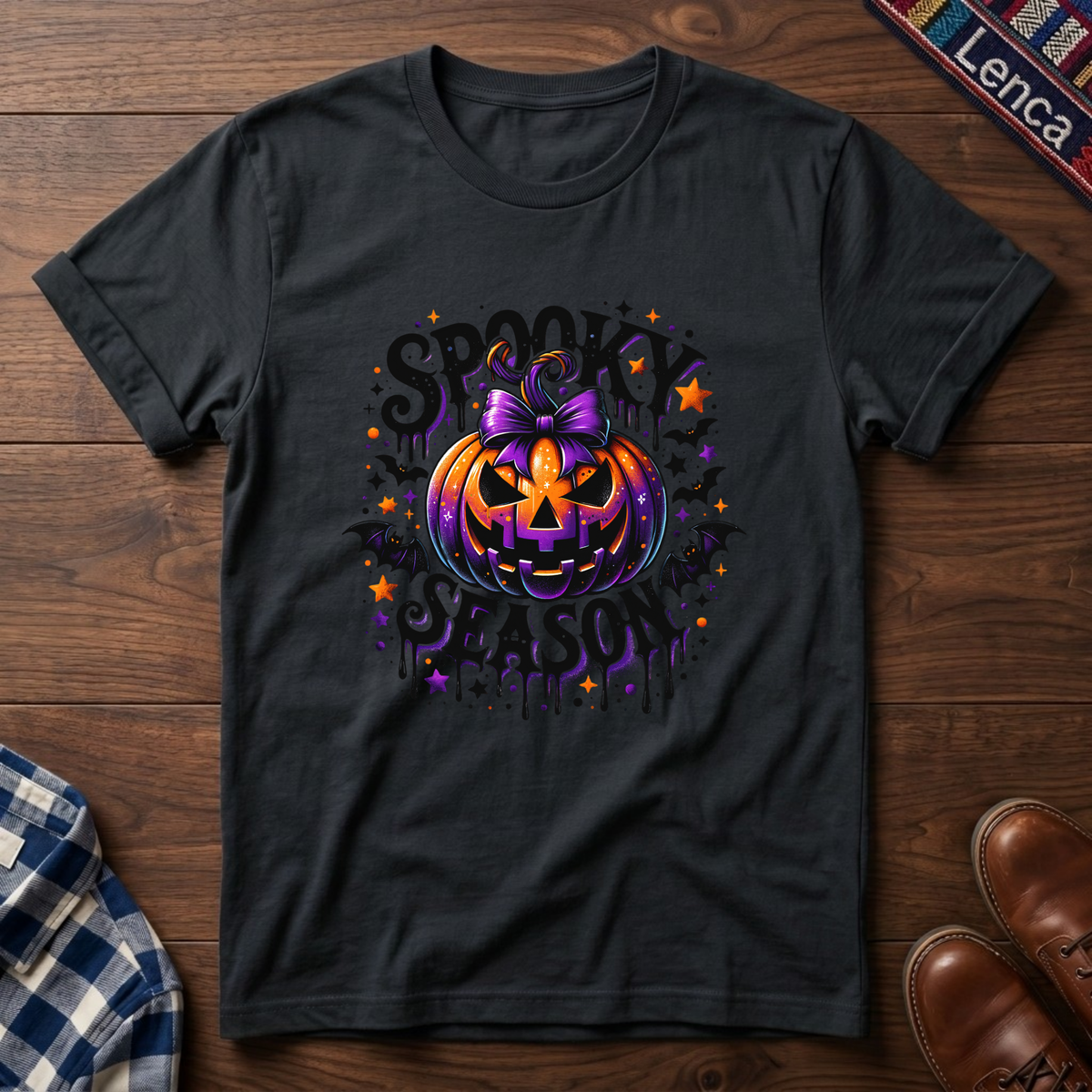A black short-sleeve t-shirt with a colorful Halloween graphic featuring a jack-o'-lantern, stars, bats, and the text 'SPOOKY SEASON'.