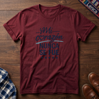Cherry red t-shirt with 'Mi Corazon Nunca' text on a wooden surface.