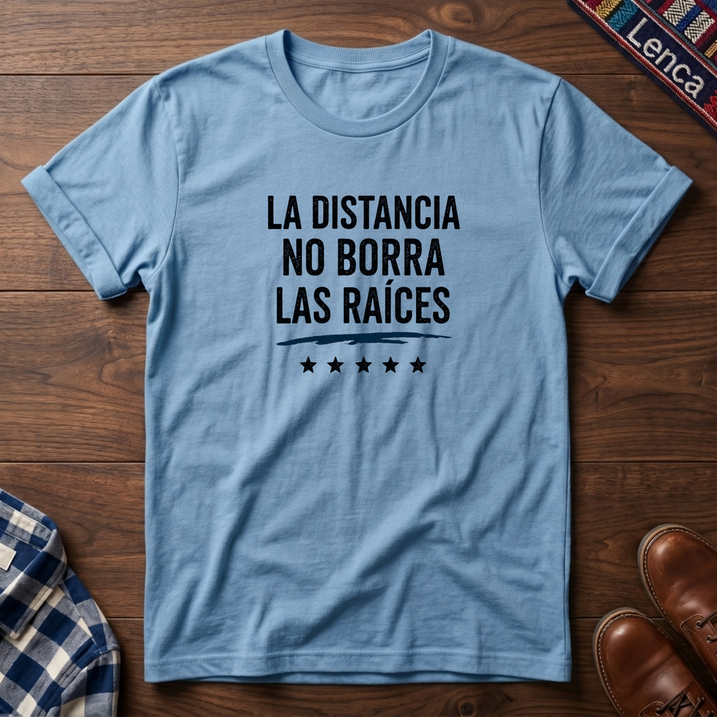 Light blue t-shirt with 'La Distancia' text on a wooden surface.