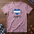 Light Pink t-shirt with a heart design featuring Honduras' flag and 'Honduras 100%' text on a wooden surface.