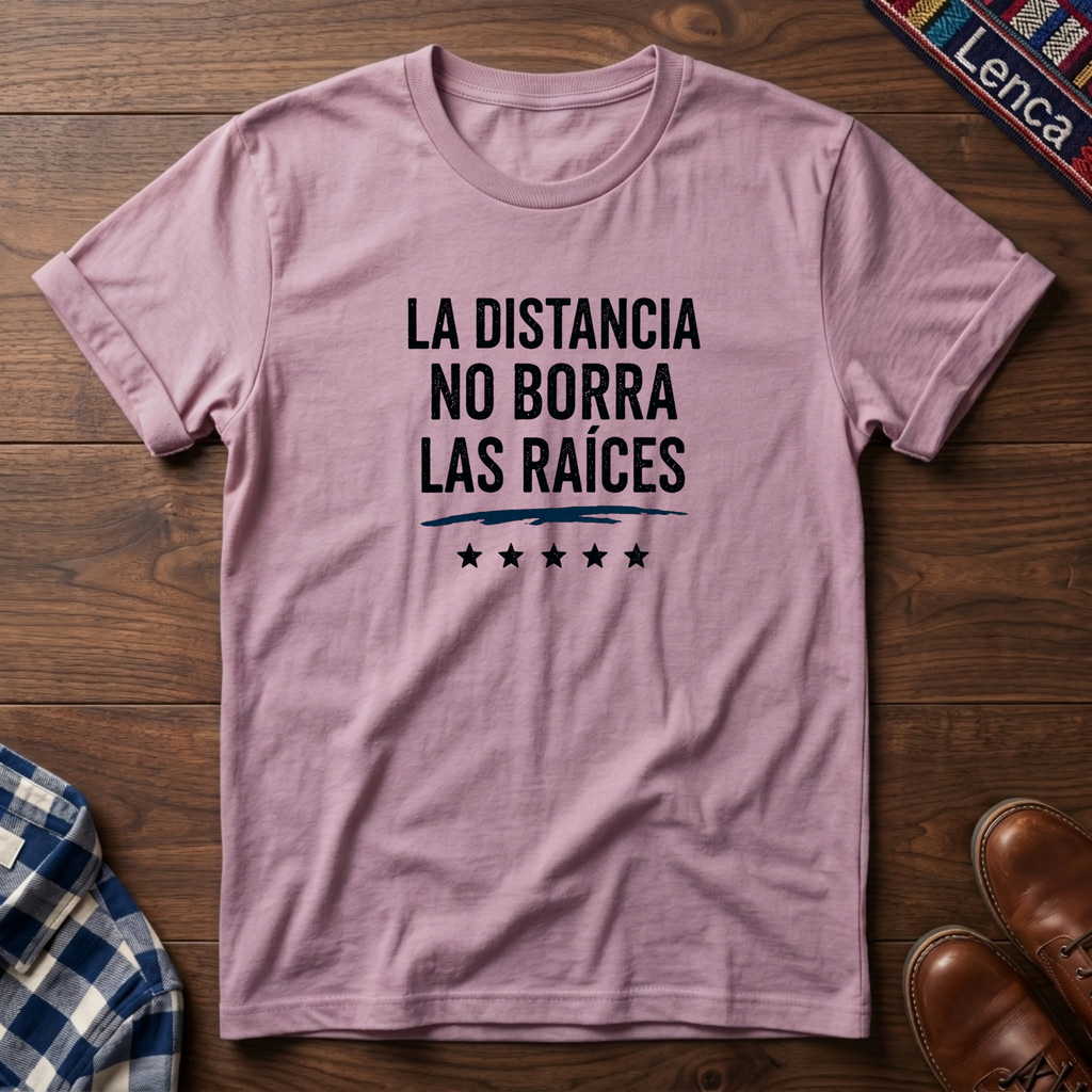 Light pink t-shirt with 'La Distancia' text on a wooden surface.