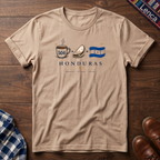 Natural t-shirt with 'Honduras' text and a Cafe Baleada Bandera graphic design on a wooden surface.