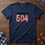 A navy blue t-shirt laid flat on a wooden surface, featuring the text 'HONDURAS 504' printed on the chest. The numbers '504' are filled with a red, white, and blue pattern resembling the Honduran Lempira, while 'HONDURAS' is printed in black.
