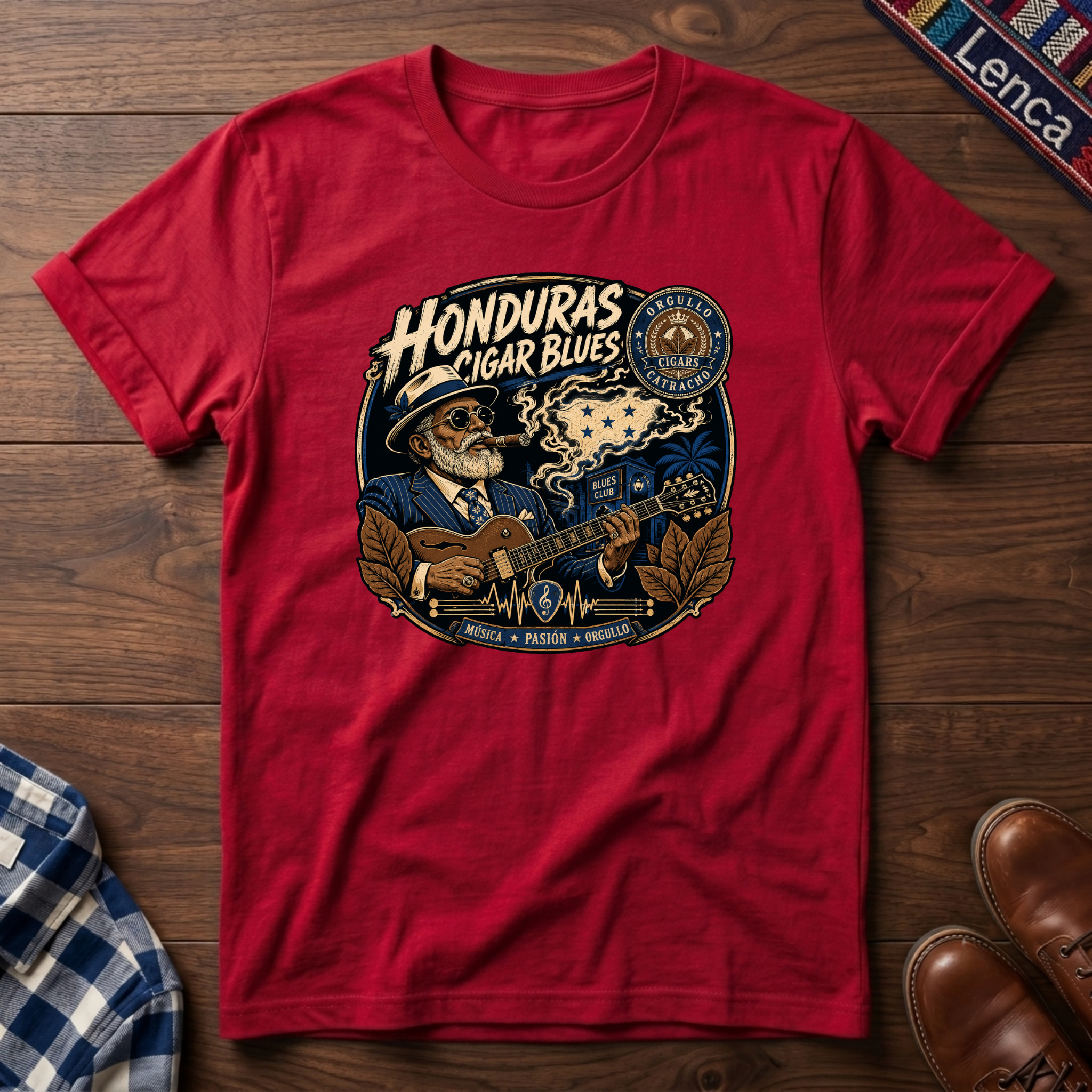 Red t-shirt with 'Honduras Cigar Blues' graphic on a wooden surface.