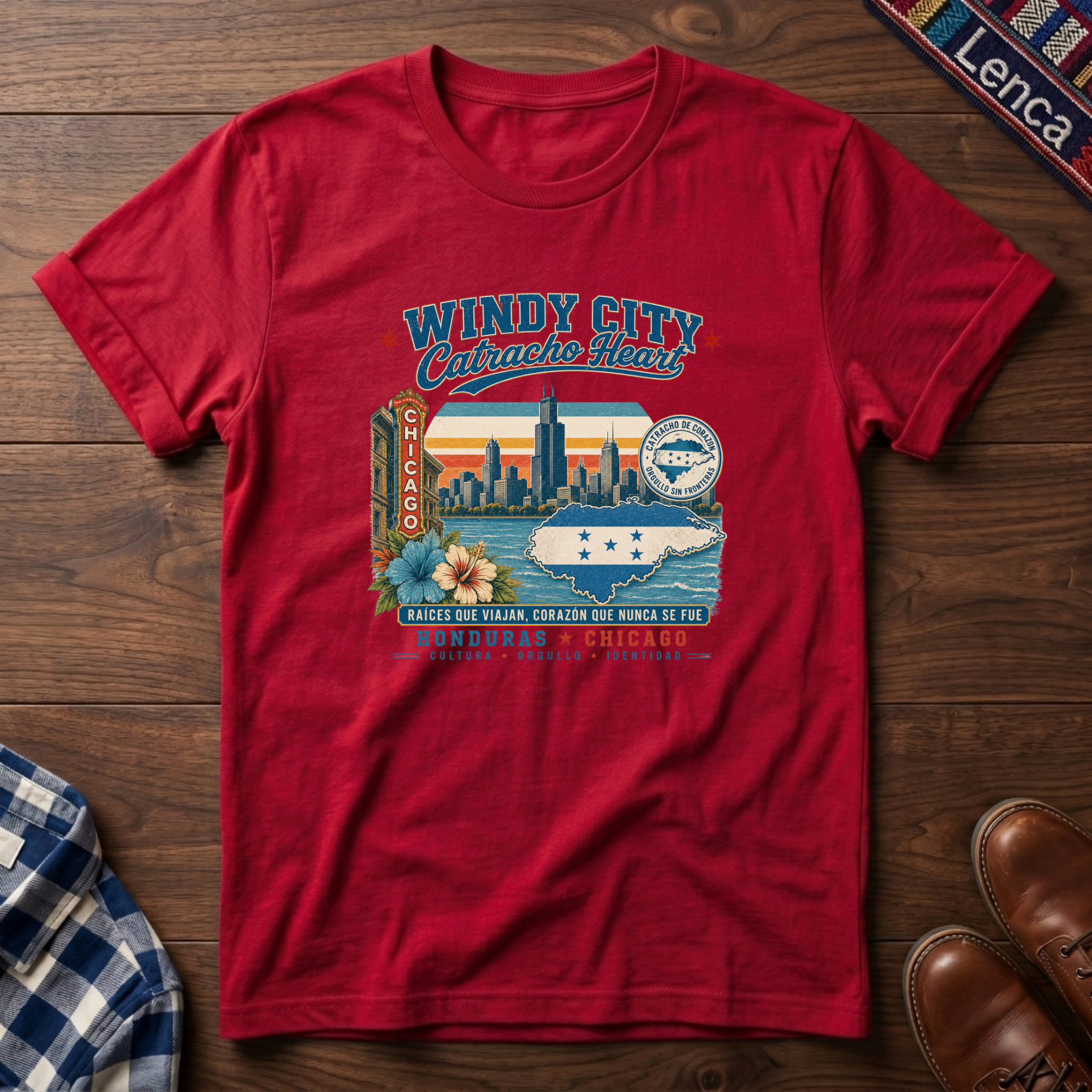 A red short-sleeve graphic t-shirt laid flat on a dark wood background, featuring a colorful vintage-style Chicago skyline and 'Windy City Catracho Heart' print.