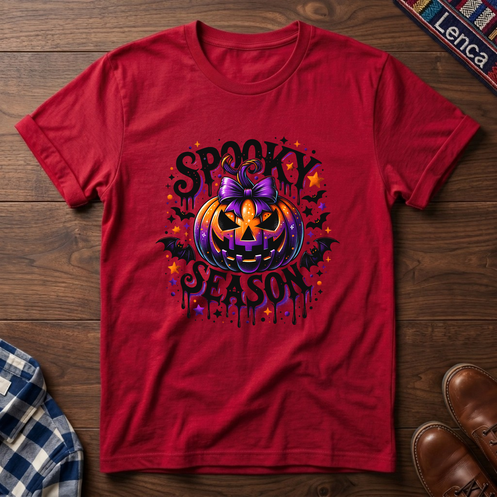 A red short-sleeve t-shirt with a colorful Halloween graphic featuring a jack-o'-lantern, stars, bats, and the text 'SPOOKY SEASON'.