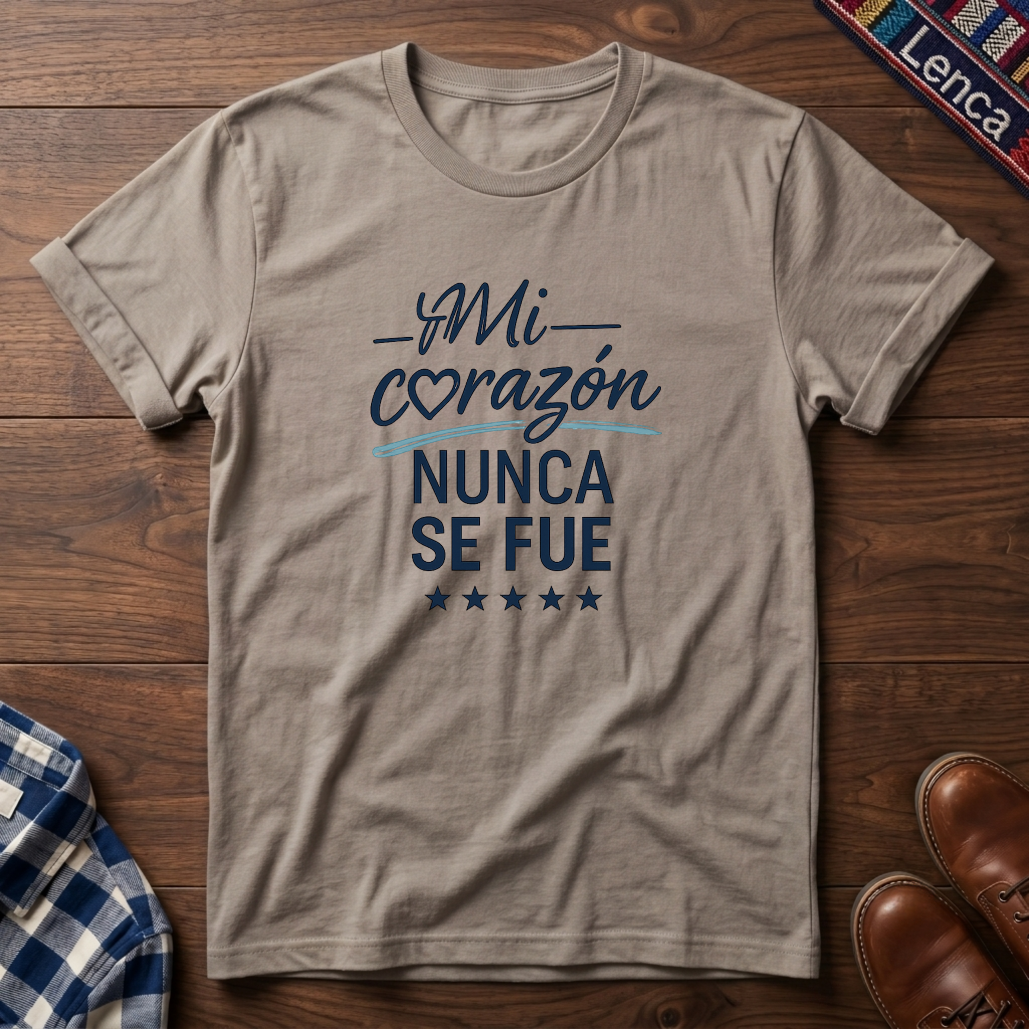 Sand t-shirt with 'Mi Corazon Nunca' text on a wooden surface.