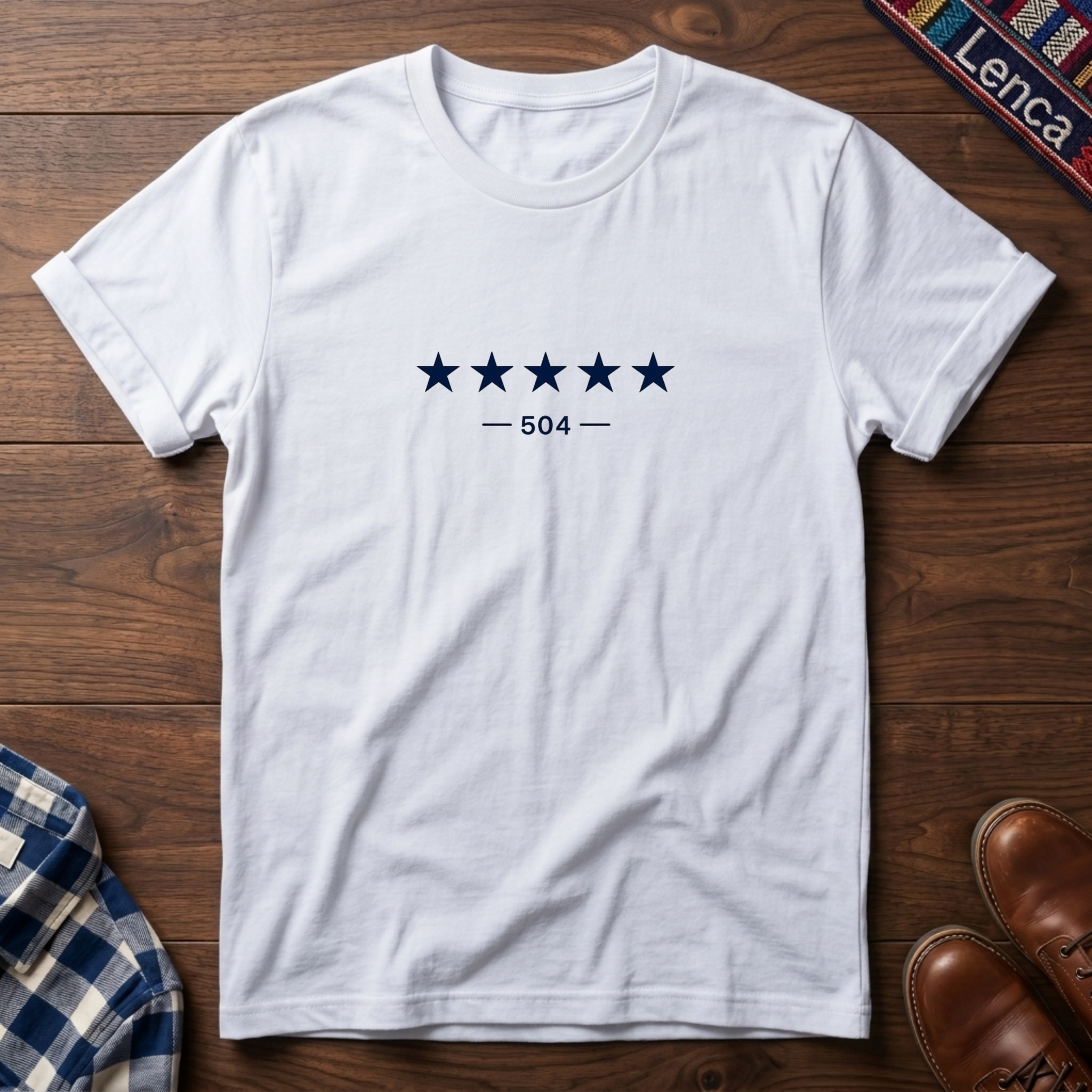 White short-sleeve crewneck t-shirt with a graphic of five dark blue stars and the text '— 504 —' on the chest, laid flat on a wooden surface.