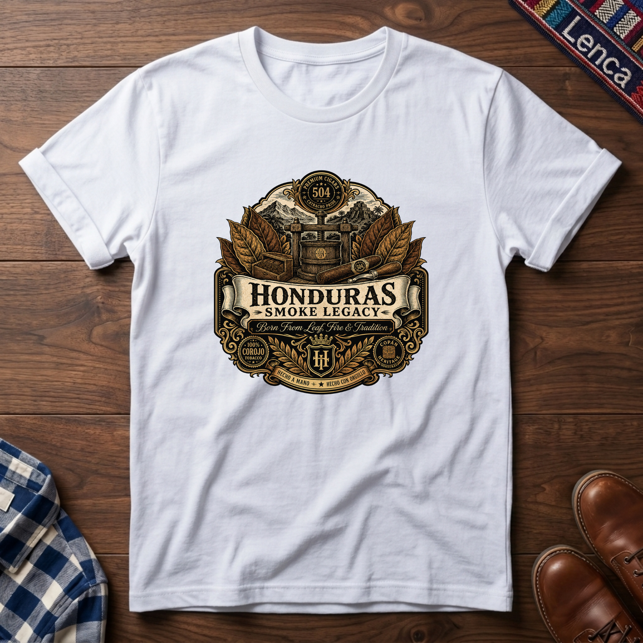 White t-shirt with 'Honduras Smoke Legacy' graphic on a wooden surface.