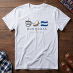 White t-shirt with 'Honduras' text and a Cafe Baleada Bandera graphic design on a wooden surface.