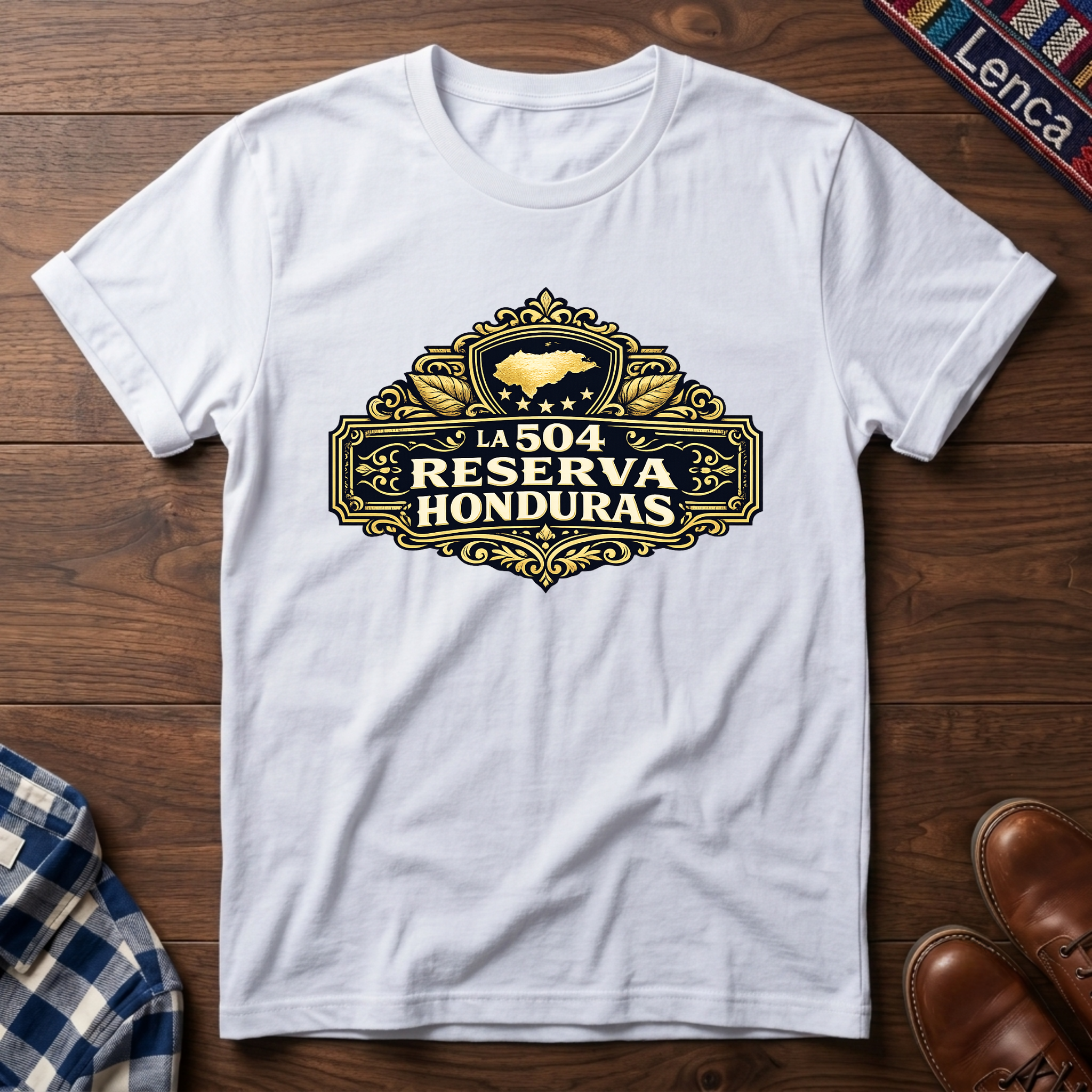 White t-shirt with 'La 504 Reserva Honduras' graphic design on a wooden surface.